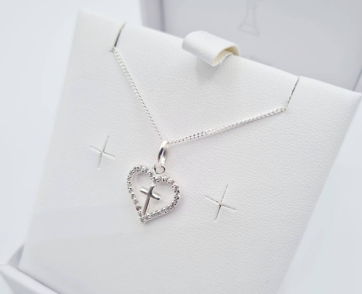 Close-up of sterling silver heart pendant with CZ cross detail