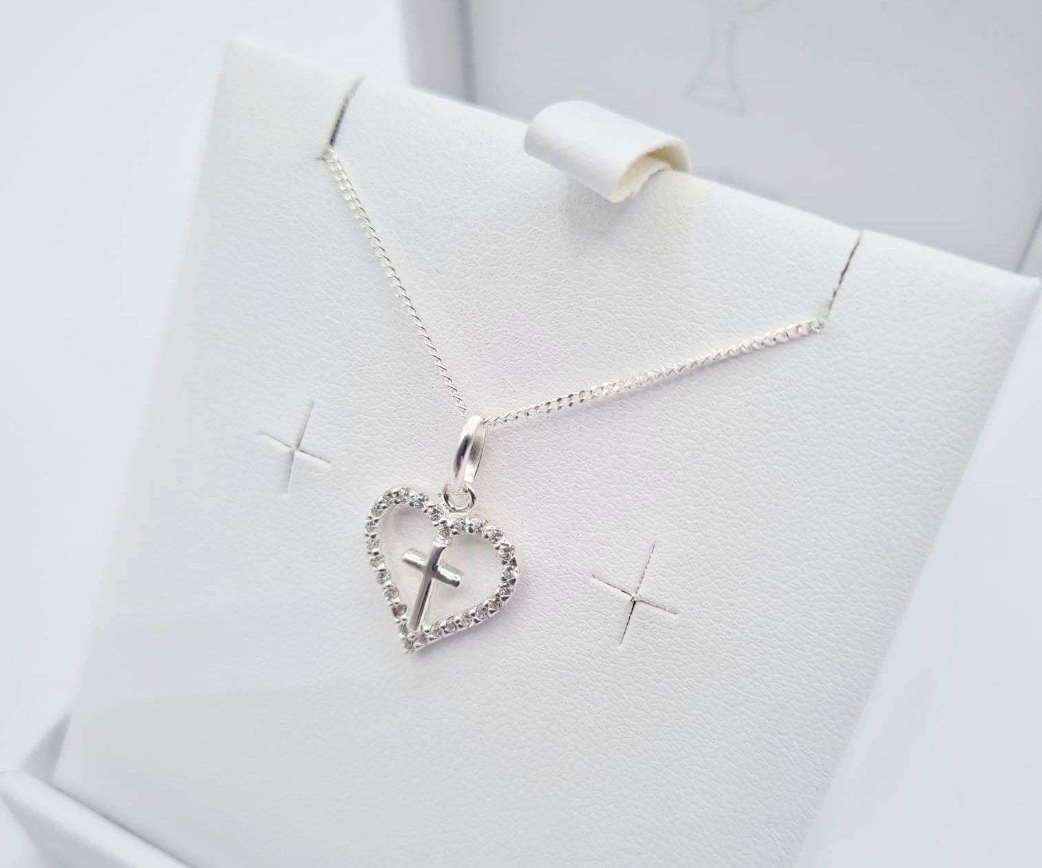 Close-up of sterling silver heart pendant with CZ cross detail