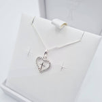 Close-up of sterling silver heart pendant with CZ cross detail