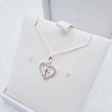 Close-up of sterling silver heart pendant with CZ cross detail