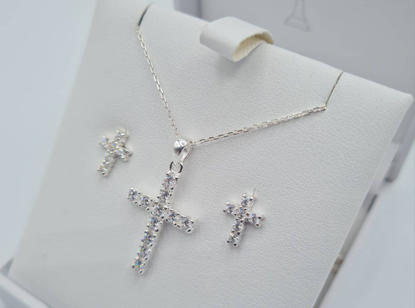 Close-up of sterling silver CZ cross pendant and cubic zirconia earrings for Holy Communion
